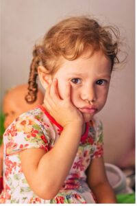 Navigating children's big emotions, sad girl with curly hair and printed dress