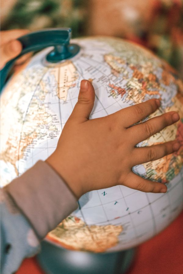 picture of a child's hand on a globe